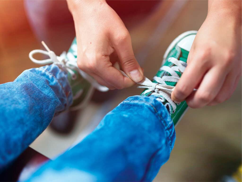 Adult tying child's shoes