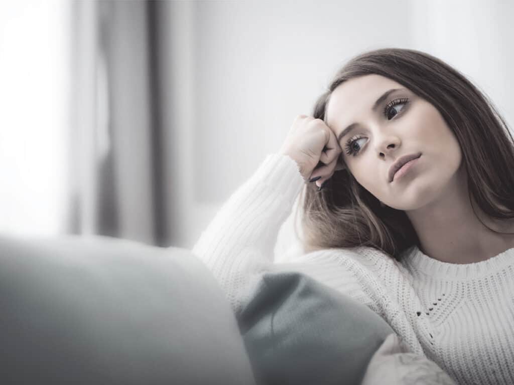 Woman on sofa looking sad