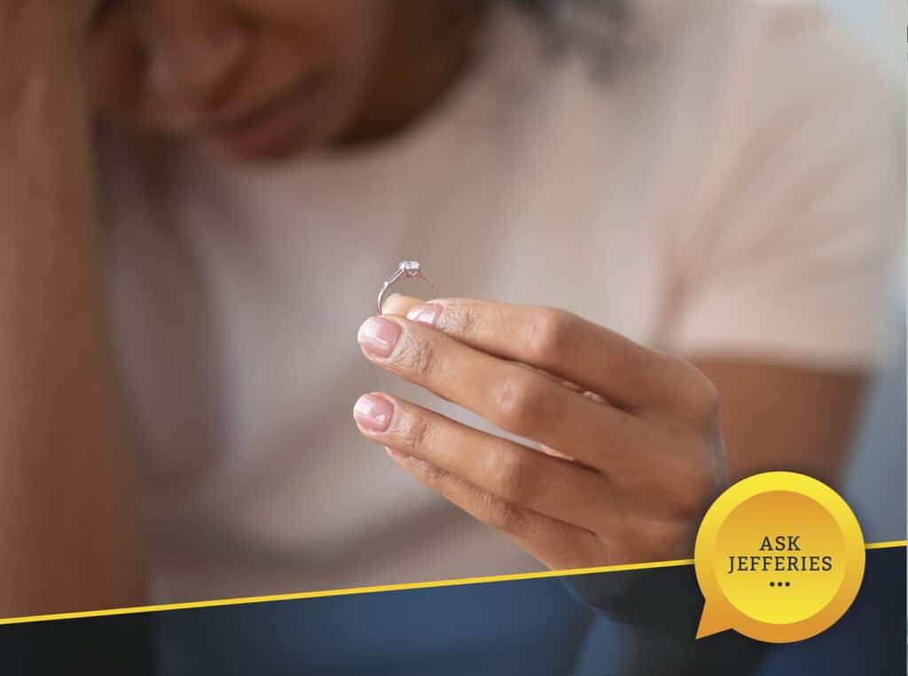 Person holding ring looking sad