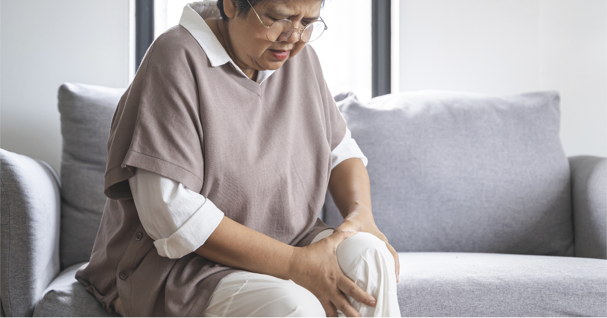old injured asian holding knee sad and hurt
